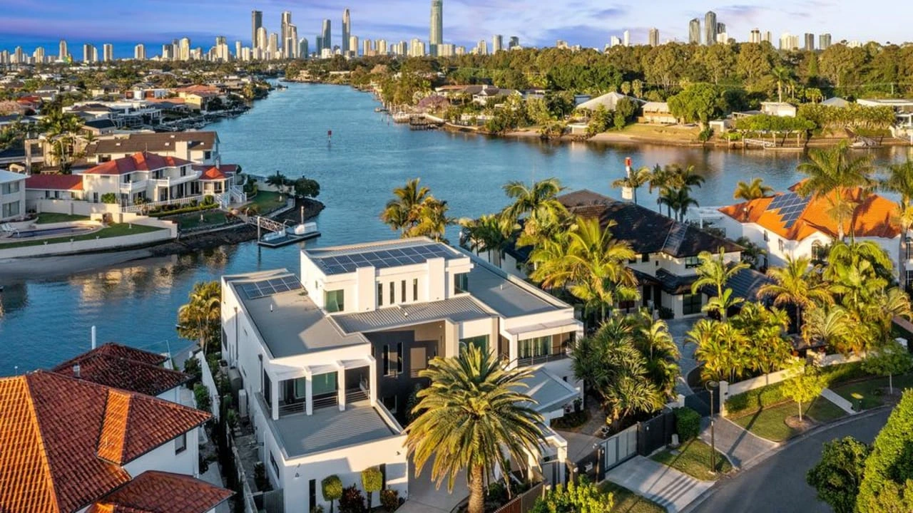 Modern Gold Coast waterfront property with rooftop solar and city skyline in background