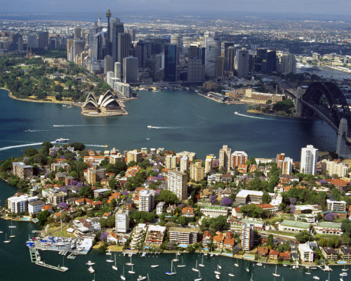 Aerial view of Sydney, Australia showing the Sydney Opera House and Harbour Bridge, with surrounding residential areas highlighting potential real estate opportunities for homebuyers.