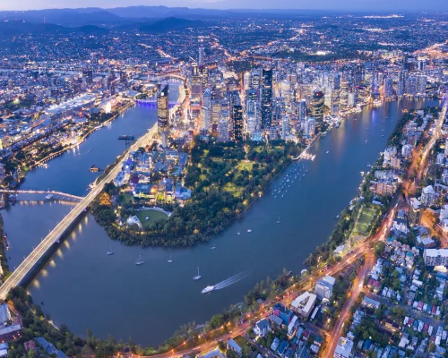 A wide aerial view of Brisbane’s CBD, riverside property areas, and middle ring suburbs with potential property investment opportunities.